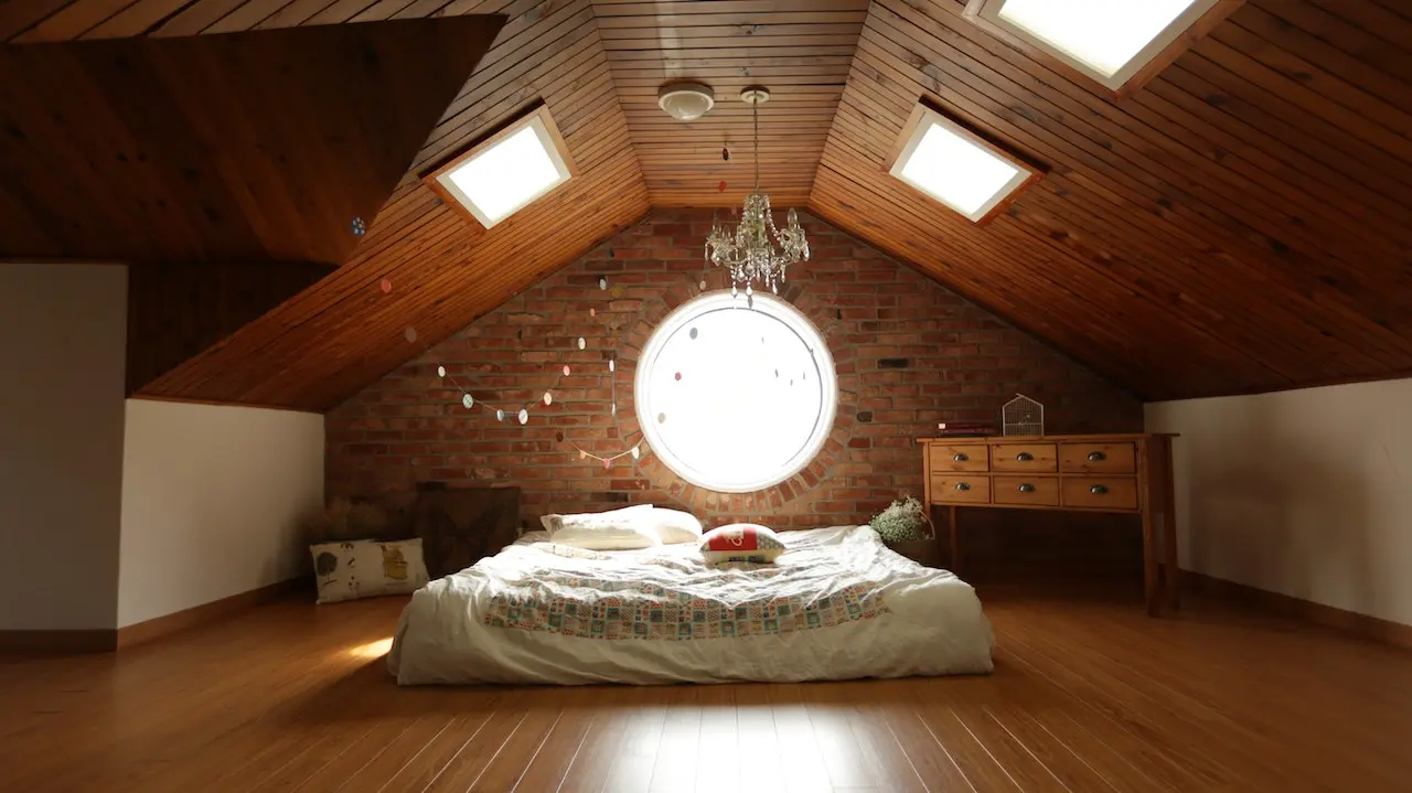اتاقی که در زیر شیروانی قرار دارد و در سقف و دیوار پنجره قرار دارد و در وسط اتاق تخت راحتی سفید و در کنار تخت میز تحریر نیز قرار دارد