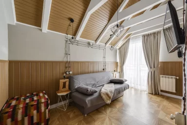 اتاقی که تم آن چوبی است و مبل راحتی و میز در آن قرار دارد